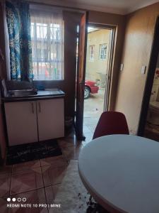 a kitchen with a table and a door to a garage at Di-Koena cottage in Springs