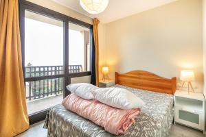ein Schlafzimmer mit einem Bett und einem großen Fenster in der Unterkunft L'Alpine Classique - Station de Ski à pied in Chamrousse