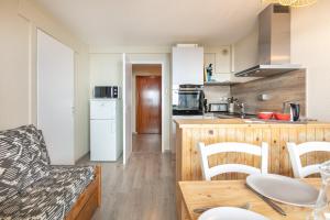 eine Küche mit Tisch und Stühlen in einem Zimmer in der Unterkunft L'Alpine Classique - Station de Ski à pied in Chamrousse