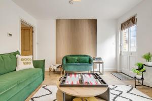 a living room with a green couch and a table at Riverside Cottage Retreat Hertford Town Sleeps 6 in Hertford