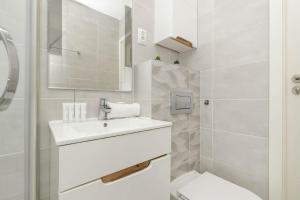 ein weißes Badezimmer mit Waschbecken und Toilette in der Unterkunft Piękny Słoneczny Apartament Blisko Plaży dla 4 Osób by Noclegi Renters in Przymorze