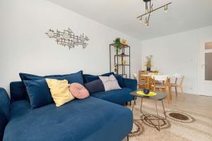 ein blaues Sofa im Wohnzimmer mit einem Tisch in der Unterkunft Piękny Słoneczny Apartament Blisko Plaży dla 4 Osób by Noclegi Renters in Przymorze
