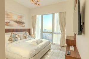 een slaapkamer met een groot bed en een groot raam bij 60th High Floor - full World islands, Downtown and Ocean View - high quality Design and Furniture - 2 Bedroom in Dubai +94 foto's