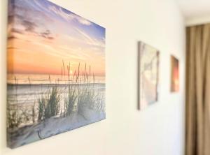 ein Bild hängt an einer Wand mit einem Bild eines Strandes in der Unterkunft City Charm Apartments 2 in Warna