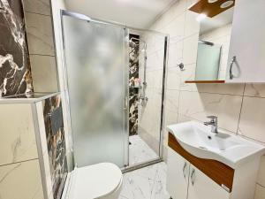 ein Badezimmer mit Dusche, Toilette und Waschbecken in der Unterkunft City Charm Apartments 2 in Warna + 40 Fotos