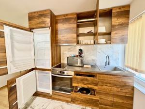 eine Küche mit Holzschränken und einer Spüle in der Unterkunft City Charm Apartments 2 in Warna