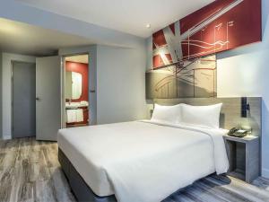 een groot wit bed in een hotelkamer bij ibis Bangkok IMPACT in Nonthaburi