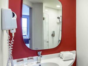 une salle de bain avec un lavabo avec un grand miroir dans l'établissement ibis Bangkok IMPACT, à Nonthaburi 71 autres photos