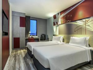 a hotel room with two beds and a desk at ibis Bangkok IMPACT in Nonthaburi