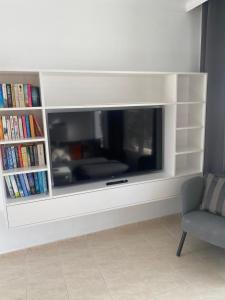 a entertainment center with a large tv and books at B17 Caleton blanco in Tías