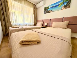 ein Hotelzimmer mit zwei Betten und einem Fenster in der Unterkunft City Charm Apartments 2 in Warna