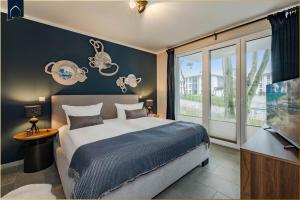 een slaapkamer met een groot bed en een groot raam bij Terrasse am Haff in Zirchow