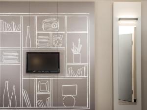 a wall mural with a tv and drawings on it at ibis Guaiba in Guaíba +40 photos