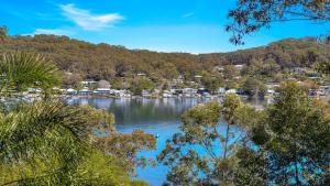 a view of a lake with houses and trees at 'Hampton Cottage' by HolidayCo in Pretty Beach +13 photos
