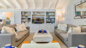 ein Wohnzimmer mit Sofas und einem Couchtisch in der Unterkunft 'Hampton Cottage' By HolidayCo in Pretty Beach