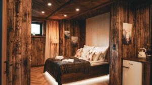 a bedroom with a bed in a room with wooden walls at Highland Apartments Pod Gubałówką in Zakopane