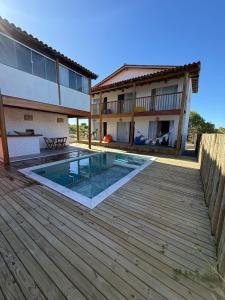 una casa con piscina en una terraza de madera en Vila Viver Caraíva, en Caraíva