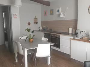 a kitchen with a table and white chairs in a kitchen at Lagnieu in Lagnieu +16 photos