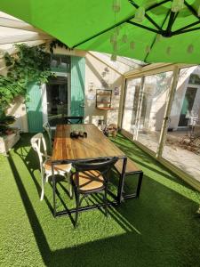 a wooden table and chairs in a room with green carpet at Effets Personnels in Orange