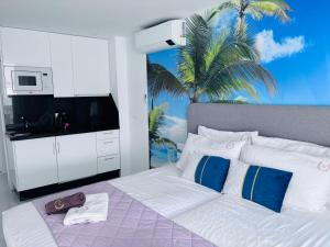 a bedroom with a bed with a tv and a palm tree at Blue Ocean Costa Adeje 504 in Playa de las Americas