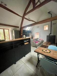 a kitchen with a table and a living room at loft à la campagne in Vermenton