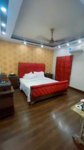 Un dormitorio con una cama grande con cabecero rojo. en Heavens appartment, en Karachi
