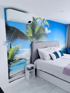 Un dormitorio con una cama con un mural de palmeras. en Blue Ocean Costa Adeje 504, en Playa de las Américas