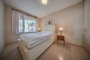 Un dormitorio con una cama blanca y una ventana. en The Exquisite Residence, en Zheleznitsa