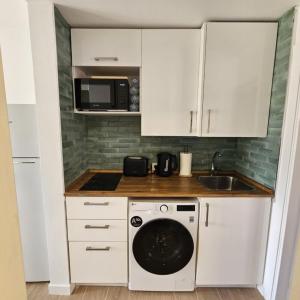 a kitchen with a washing machine and a microwave at Duna Lagoon in Corralejo