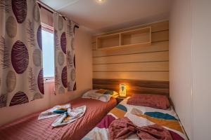 a bedroom with two beds and a window at Mobil-home Elegance - 3 chambres in Seillac