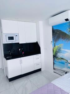 Una cocina blanca con fregadero y microondas. en Blue Ocean Costa Adeje 504, en Playa de las Américas 54 fotos más