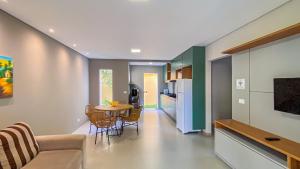 una cucina e un soggiorno con tavolo e sedie di Residencial IL Pevero, condomínio com piscina e área gourmet a uma quadra da Praia de Taperapuã aptos com 2 quartos a Porto Seguro