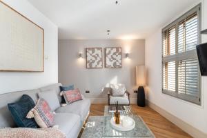 a living room with a couch and a table at NEW! Fulham 1-bed Apartment with Patio in London