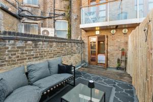a patio with a couch and a table and a building at NEW! Fulham 1-bed Apartment with Patio in London