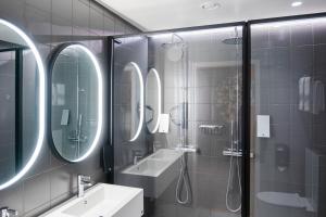 a bathroom with mirrors and a sink and a shower at Citybox Stockholm in Stockholm