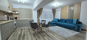 a living room with a blue couch and a table at Ultracentral Luxury in Piteşti