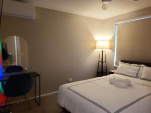 a bedroom with a bed and a table and a lamp at Private Room 2- Affordable Luxury in Craigieburn