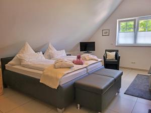 a bedroom with a large bed with a stool at Wellness Appartements Ostfriesland in Ihlowerfehn