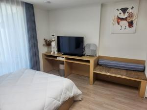 a bedroom with a bed and a television on a desk at 등대해수욕장 써밋베이 숙소#13 in Sajin