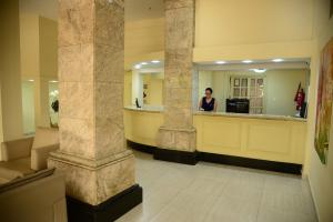 a woman standing at a counter in a lobby at River Park Hotel in Resende
