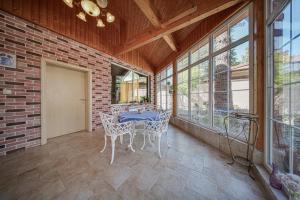 Un comedor con mesa y sillas y ventanas. en The Exquisite Residence, en Zheleznitsa 2 fotos más