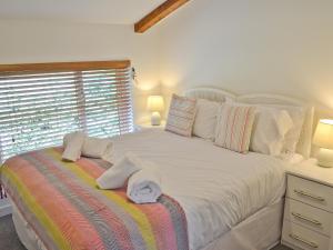 Un dormitorio con una cama blanca con toallas. en Porhellik, en Zelah 3 fotos más