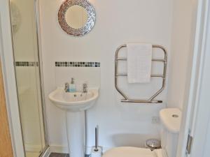 Un baño con lavabo, inodoro y espejo. en Porhellik, en Zelah