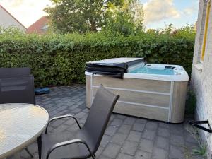 un bain à remous assis à côté d'une table et de chaises dans l'établissement Privé wellness Zen aan zee met jacuzzi barrelsauna en infraroodsauna, à Breskens