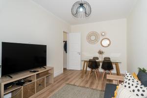 a living room with a flat screen tv and a table at The Family Nest Amadora T4 in Amadora