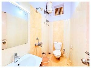 ein Badezimmer mit Toilette, Waschbecken und Spiegel in der Unterkunft HOTEL SWARNA VILLA Near Sea Beach & Jagannath Temple - Fully Air Condition with All Luxury Rooms With Attached-Balcony Free Wifi & Restaurant - Free Parking -Facilities# Boutique Services - A Top Rated Hotel In Puri in Puri + 32 Fotos