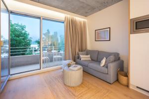 Babel Community Hôtel Lille - Villeneuve d'Ascq في فيلنوف داسك: غرفة معيشة مع أريكة ونافذة كبيرة
