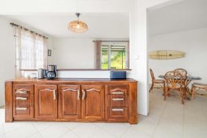 a kitchen with a wooden cabinet and a table at Lakaz Lagon - Entre Vue Mer & Montagne, Jacuzzi in La Gaulette +30 photos