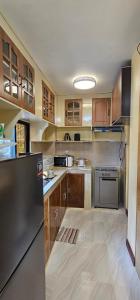 Una cocina con gabinetes de madera y un refrigerador negro. en IBM Homestay, en Butuán 7 fotos más