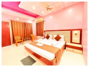 ein Schlafzimmer mit einem großen Bett in einem Zimmer in der Unterkunft HOTEL SWARNA VILLA Near Sea Beach & Jagannath Temple - Fully Air Condition with All Luxury Rooms With Attached-Balcony Free Wifi & Restaurant - Free Parking -Facilities# Boutique Services - A Top Rated Hotel In Puri in Puri
